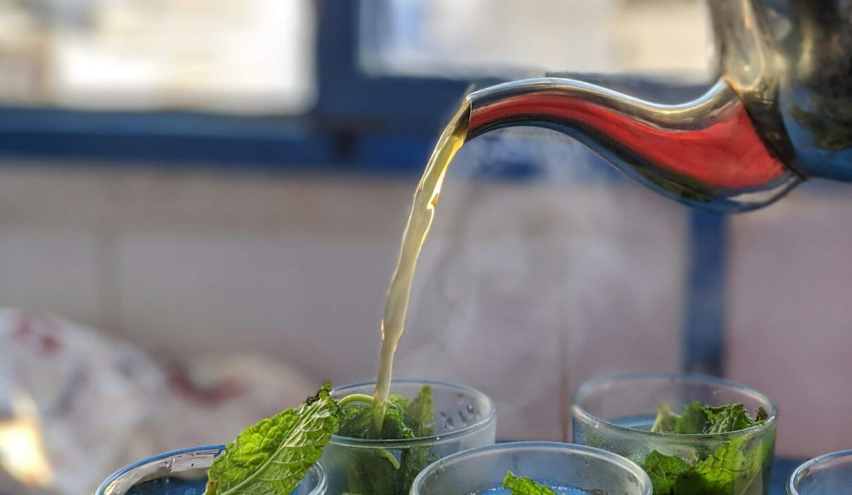 Thé à la menthe versé en hauteur dans des verres marocains décorés