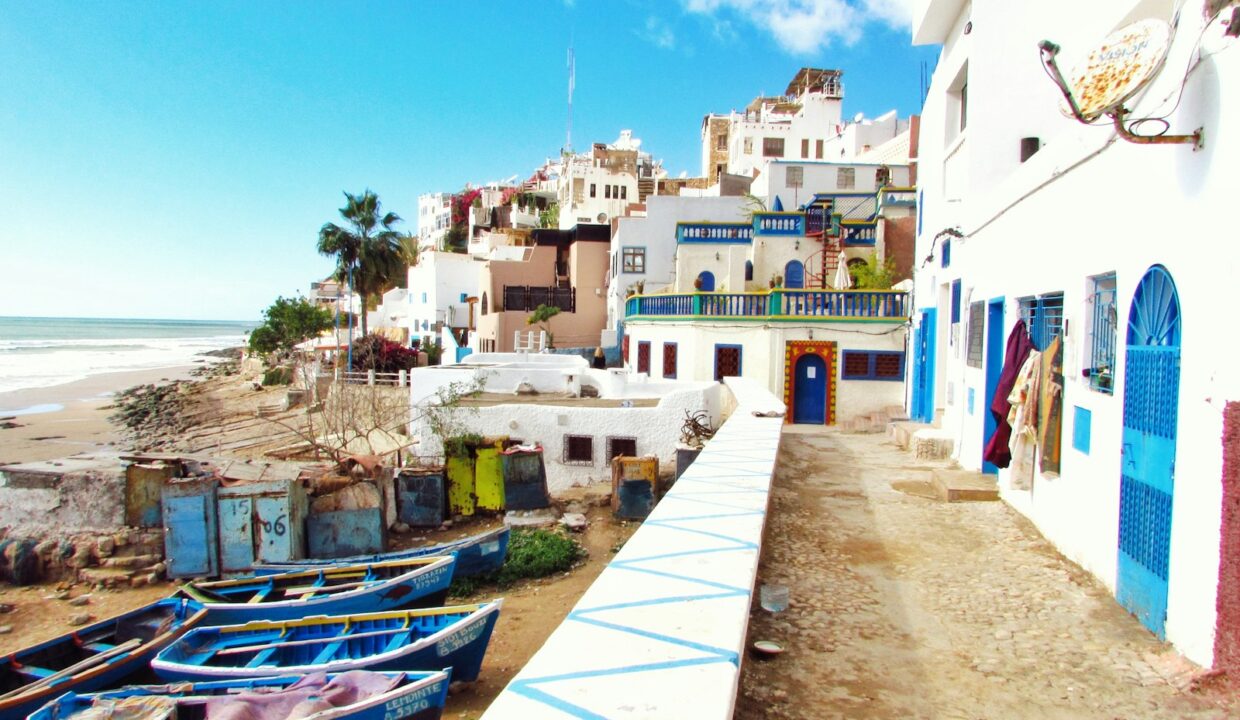 Village côtier aux maisons blanches et bleues et barques de pêche à Dakhla