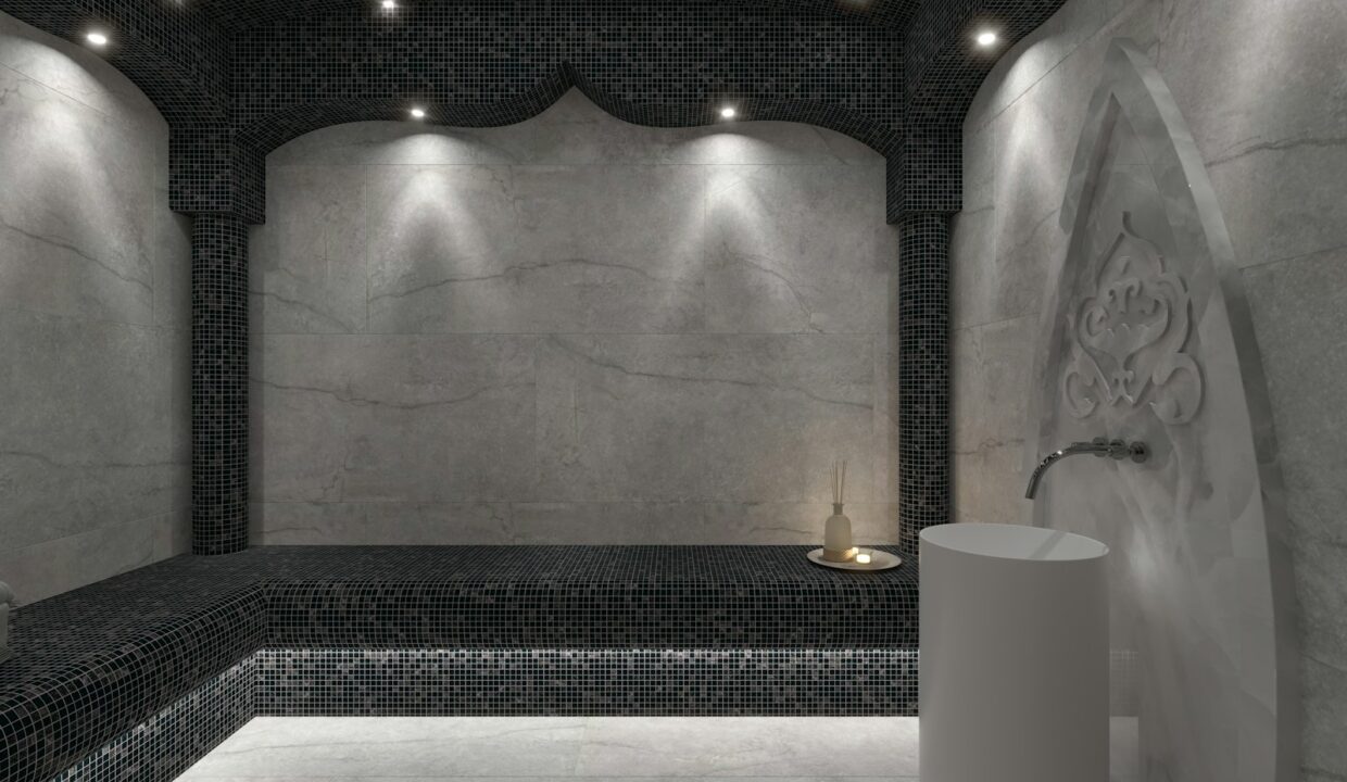 Salle de hammam traditionnel marocain en pierre, éclairage tamisé et vasque centrale